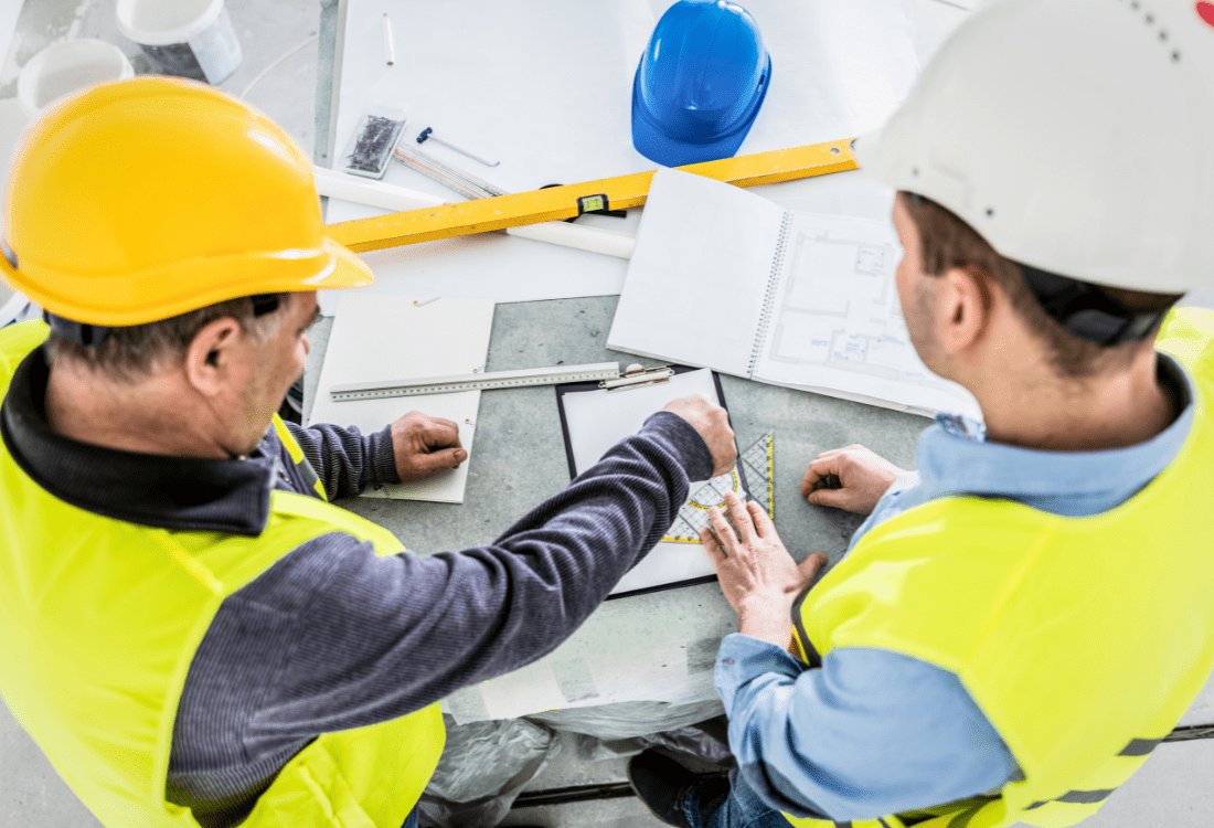 Two construction professionals are engaged in project planning exemplifying the strategic collaboration facilitated by construction recruitment agencies.